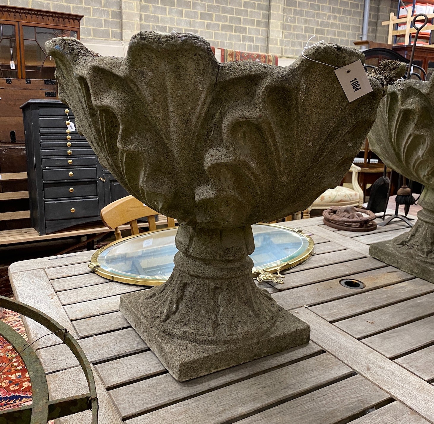 A pair reconstituted stone garden urns mounted with stylised leaves